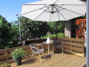 een tafel en twee stoelen en een paraplu op een terras bij Stoomzicht in Wijlre