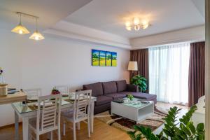 uma sala de estar com um sofá e uma mesa em Rose Garden Residences em Hanói