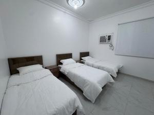 a room with two beds and a chalkboard in it at شقة جديدة ثلاث غرف نوم داخل حدود الحرم in Al Madinah