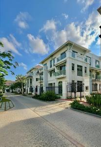 a white apartment building on a street at Biệt thự sân vườn sang trọng Hayha Villa - Tropical Garden Khem Beach in Phu Quoc