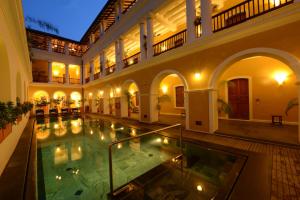 uma piscina interior num edifício com um edifício em Palais De Mahe - CGH Earth em Pondicherry