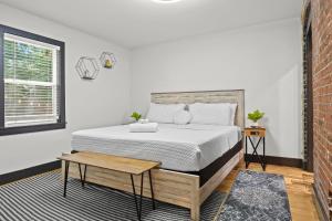 Un dormitorio con una cama y una pared de ladrillo. en Unique Black Home in the Heart of Shelby Park, en Louisville 86 fotos más