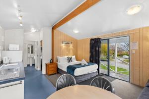a hotel room with a bed and a kitchen at Hampshire Holiday Parks - Queenstown Lakeview in Queenstown