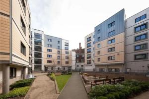una hilera de edificios con bancos en un patio en Albert Court in Liverpool, en Liverpool