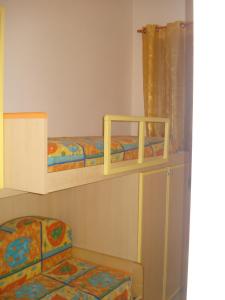 2 łóżka piętrowe w pokoju z krzesłem w obiekcie Appartamento Piano Ponente w mieście Isola delle Femmine