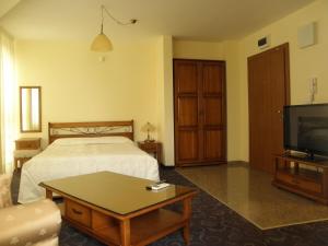 a hotel room with a bed and a tv at Anteya Serdika Apartments in Sozopol
