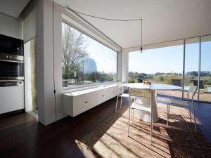 a kitchen with a table and chairs and a large window at Contemporary Caminha Villa 2 Bedrooms Villa Oceanic Escape Private Pool & Uninterrupted Sea Views North Portugal in Caminha