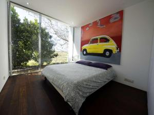 a bedroom with a painting of a yellow car on the wall at Contemporary Caminha Villa 2 Bedrooms Villa Oceanic Escape Private Pool & Uninterrupted Sea Views North Portugal in Caminha +18 photos