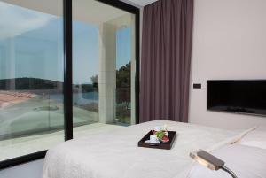 a bedroom with a bed with a tray of flowers on it at Stunning Seafront House In Istria Villa Vrsar Magnifique Contemporary 5 Bedroom Villa Sauna And Gym Direct Access To Sea in Vrsar