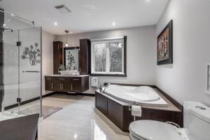 a bathroom with a tub and a toilet and a sink at Chalet in the Woods, Serenity in Saint Come +38 photos