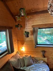 a bedroom with a bed in a room with wooden walls at Cabane Colette in Ieper