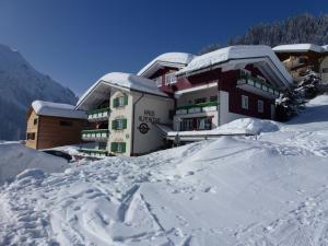 un edificio cubierto de nieve en una montaña en Haus Alpenecho, en Mittelberg