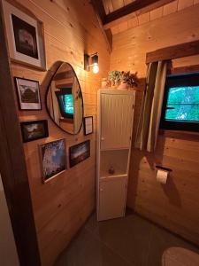 a bathroom with a mirror and a cabinet in a room at Cabane Colette in Ieper