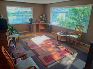 a living room with a table and chairs and a large window at Private Bedroom at Riverfront House in Kamloops