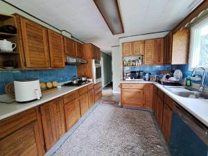 a kitchen with wooden cabinets and a sink at Private Bedroom at Riverfront House in Kamloops