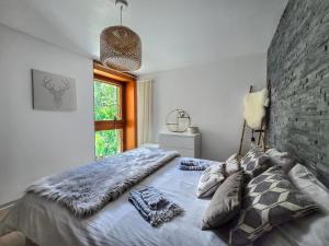 a bedroom with a large bed and a brick wall at L'AvantGardiste, Spacious 6 bedrooms duplex, panoramic view in Crans-Montana