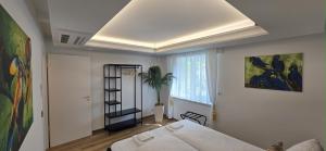 a bedroom with a bed in a room with a window at Exotic Tropical Palace - ComfyHome Apartments Stuttgart in Stuttgart
