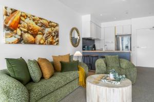 a living room with a couch and a table at Belle Escapes 14 Harbour Lights with tranquil ocean views in Cairns