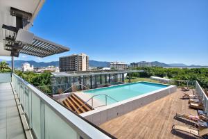 a balcony with a swimming pool on top of a building at Belle Escapes 14 Harbour Lights with tranquil ocean views in Cairns