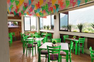 a restaurant with green chairs and tables and windows at Beautiful apartment in Orizaba in Cedro
