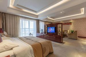 a large bedroom with a large bed and a flat screen tv at Xin Sheng Da Hong Sheng International Hotel in Kunming