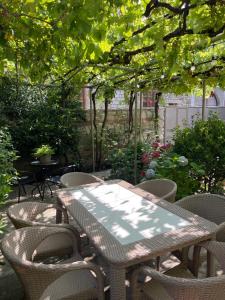 un tavolo e sedie in un giardino alberato di Mari Guest House a Telavi