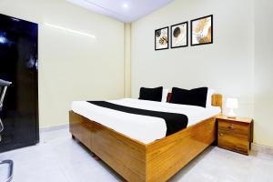 a bedroom with a bed with a wooden frame at Hotel O Mother Touch in Indirapuram