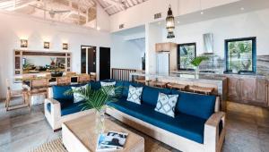 Una sala de estar con un sofá azul y una mesa. en Batu Karang Lembongan Resort & Spa, en Nusa Lembongan
