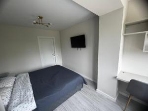a bedroom with a bed and a tv on the wall at NOI-Apartment in Căuşeni