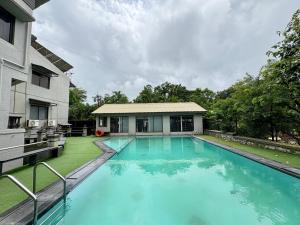a swimming pool in the backyard of a house at HoneyBee Resort Lonavala in Lonavala