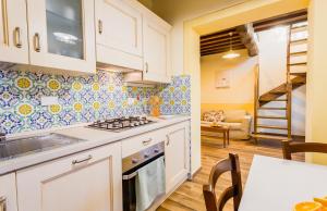 a kitchen with a stove and a dining room at Olivo Cottage - Monti 1824 in Casole dʼElsa