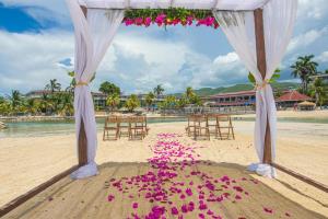 a wedding ceremony on the beach with flowers on the sand at Catalonia Montego Bay - All Inclusive in Montego Bay +263 photos