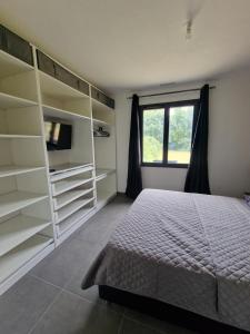 a bedroom with a bed and shelves and a window at Villa en Provence - Sisteron in Sisteron
