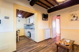 a living room with a table and a kitchen at Olivo Cottage - Monti 1824 in Casole dʼElsa
