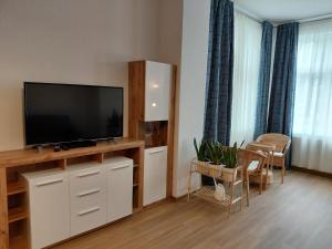 a living room with a flat screen tv on a entertainment center at Haus Troja in Warnemünde