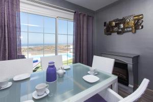 een eetkamer met een glazen tafel met stoelen en een open haard bij Suite Golf Caleta Abril in Caleta De Fuste