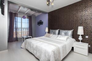 een slaapkamer met een groot bed en een muur bij Suite Golf Caleta Abril in Caleta De Fuste