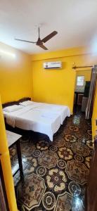 a room with two beds and a yellow wall at Samhen guest house in Majorda