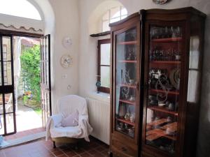 ein Wohnzimmer mit einem Porzellankschrank und einem Stuhl in der Unterkunft B&B Sul Cammino in Dolcedo