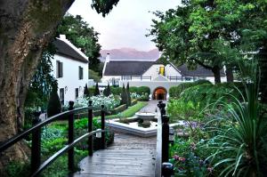 a wooden walkway leading to a garden area at Grande Roche Hotel in Paarl
