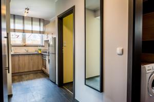 a kitchen with a yellow door and a sink at Apartament Skandynawski in Władysławowo