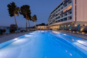 a swimming pool in front of a building at night at Mirage Chalkida City Resort in Chalkida