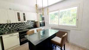a kitchen with a glass counter top and a window at Bas de villa T3 avec piscine in Marseille
