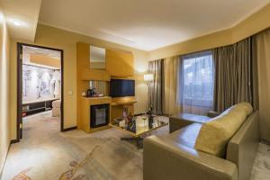 a living room with a couch and a fireplace in a room at Beijing New World Center Tongpai Hotel in Beijing