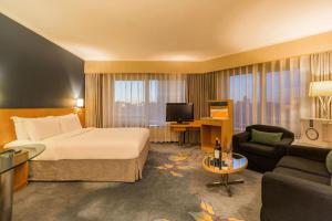 a hotel room with a bed and a living room at Beijing New World Center Tongpai Hotel in Beijing