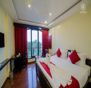 蓬蒂切里RivieraaHotel的酒店客房,配有一张带浴袍的床