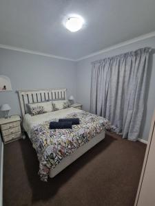 a bedroom with a bed and a window at 180 Mont Blanc in Gordonʼs Bay