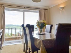 a dining room with a table and chairs and a window at Llys Aled in Llanedwen