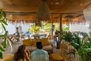 two people sitting on a couch in a living room at La Réserve-Comporta by Terresens in Carvalhal