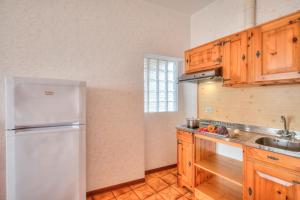 a kitchen with a white refrigerator and wooden cabinets at Residence Bellevue in Tremosine Sul Garda